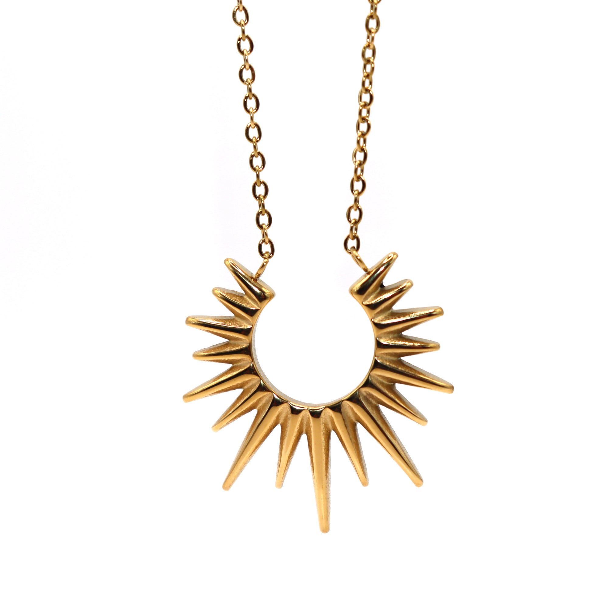 Gold sunburst pendant necklace on a white background