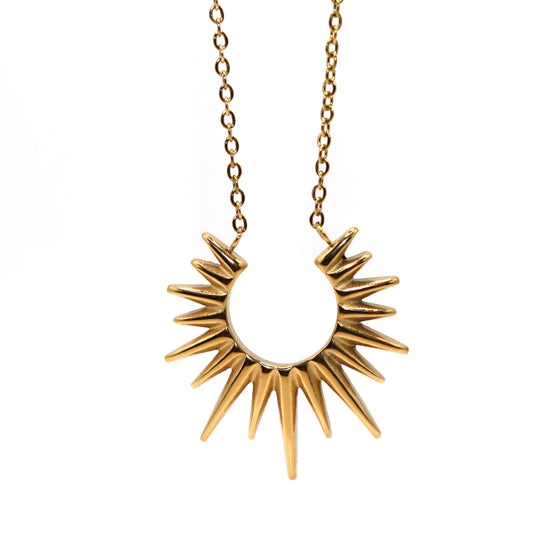 Gold sunburst pendant necklace on a white background