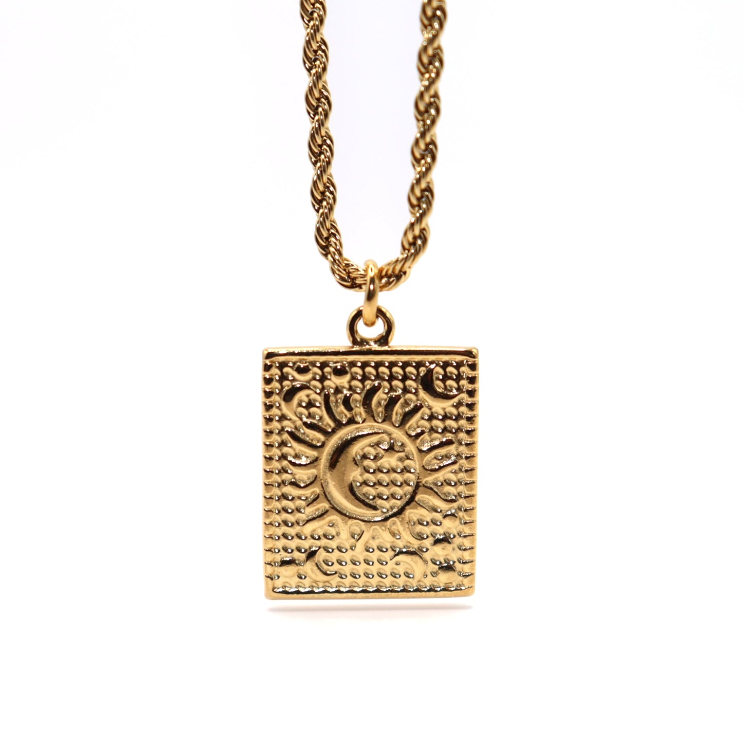 Gold necklace with a square pendant featuring sun and moon designs on a white background