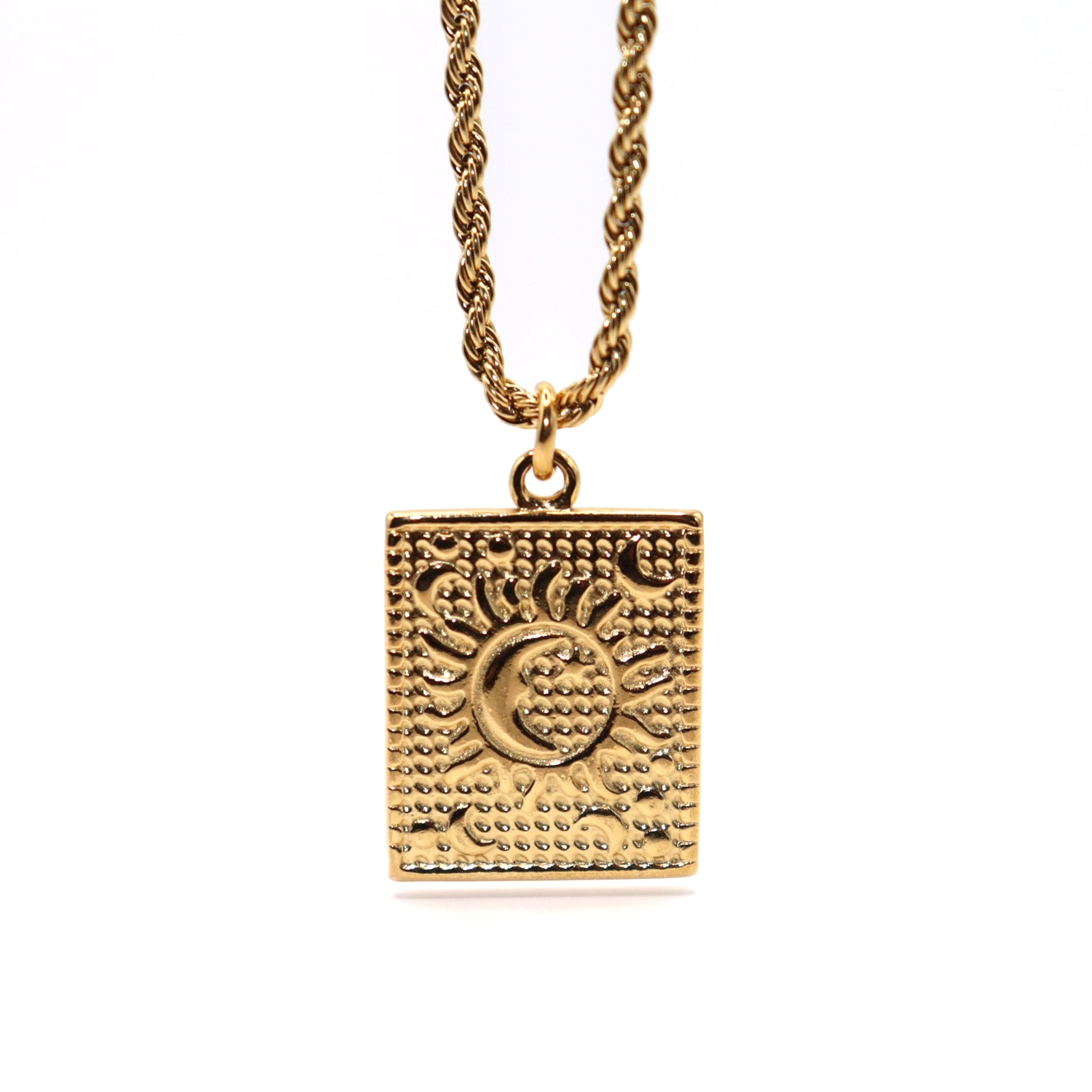Gold necklace with a square pendant featuring sun and moon designs on a white background