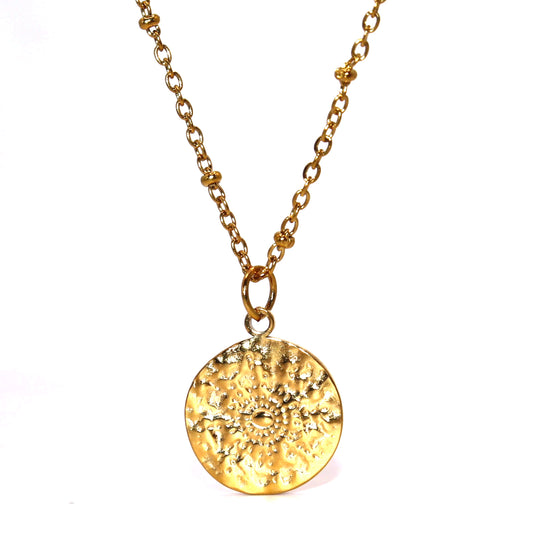 Gold necklace with a textured round pendant on a white background